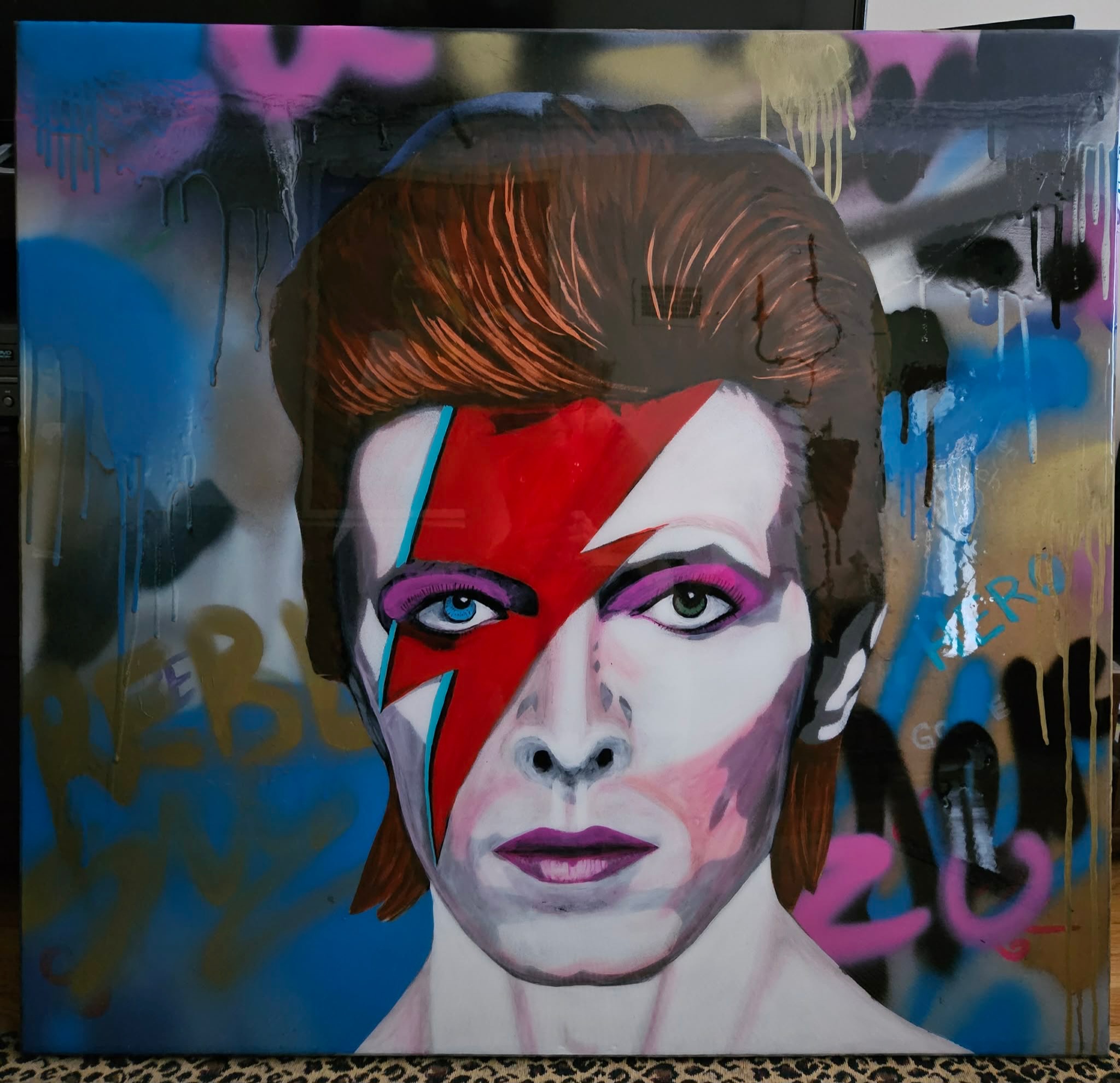 David Bowie portrait with a red lightning bolt, purple eyeshadow, and layers of colourful graffiti